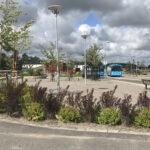 Bussstation med väl planerad infrastruktur, växter, belysning och moderna möbler